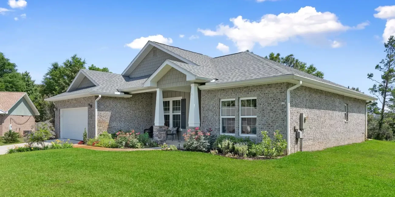 Real Estate 2 Ultra high quality real estate photography services green grass grey brick house grey roof sunny day blue sky with white clouds
