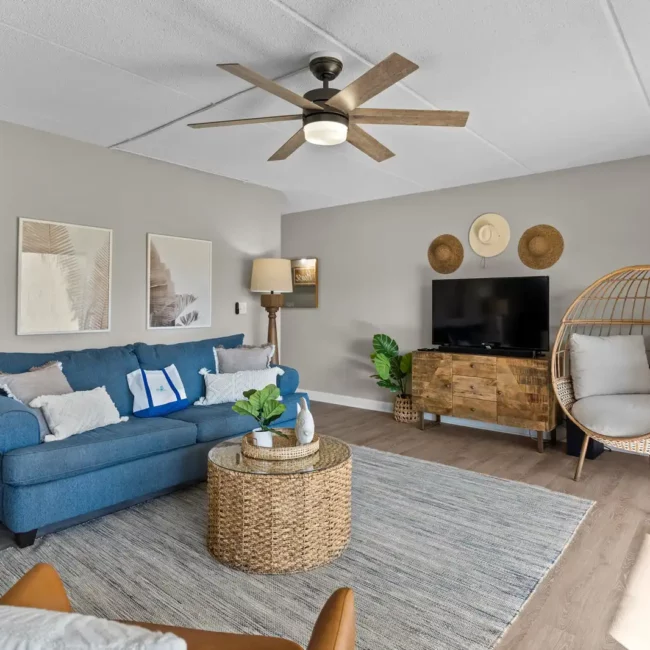 Pensacola Real Estate photography Interior of Home blue couch with ciling fan and grey area rug