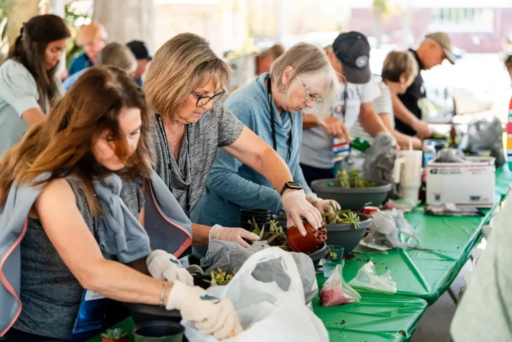 Corporate Event Photography & Videography 13 Attendees in gloves potting plants together at a company community day