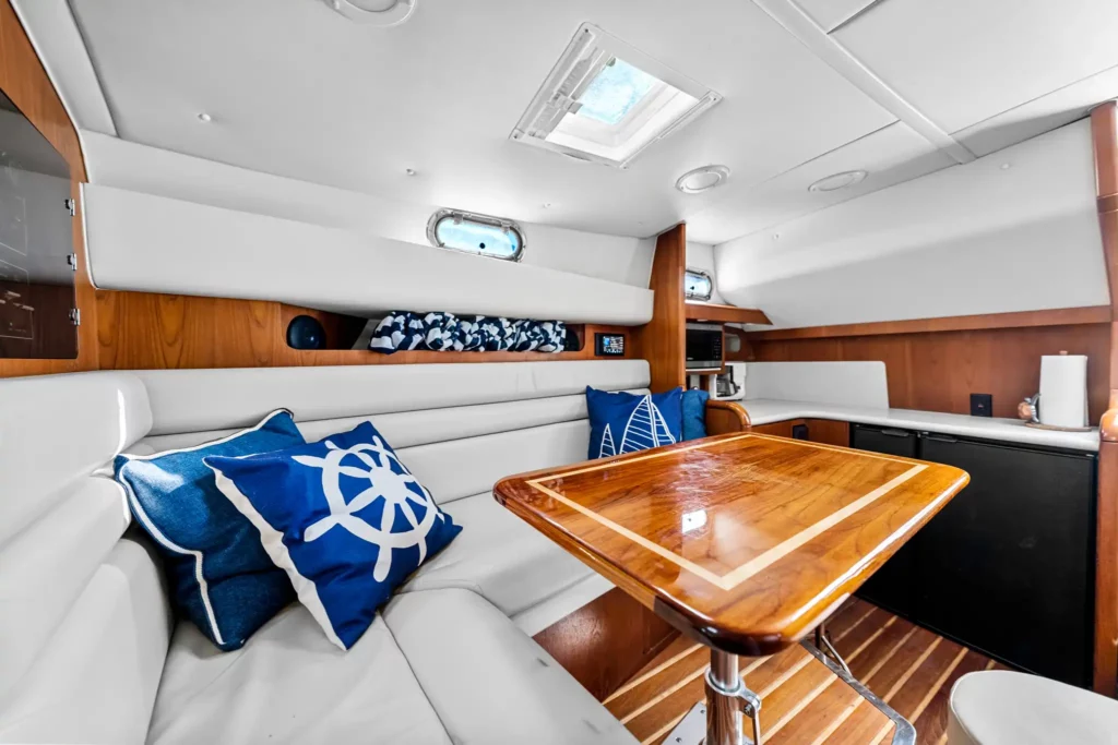 Marine Photography 4 Salon and galley of a sportfishing yacht: teak dinette, blue anchor-print cushions and overhead hatch light