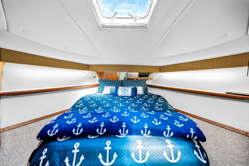 Marine Photography 5 Forward stateroom with the berth made up in anchor-print linen under a deck hatch