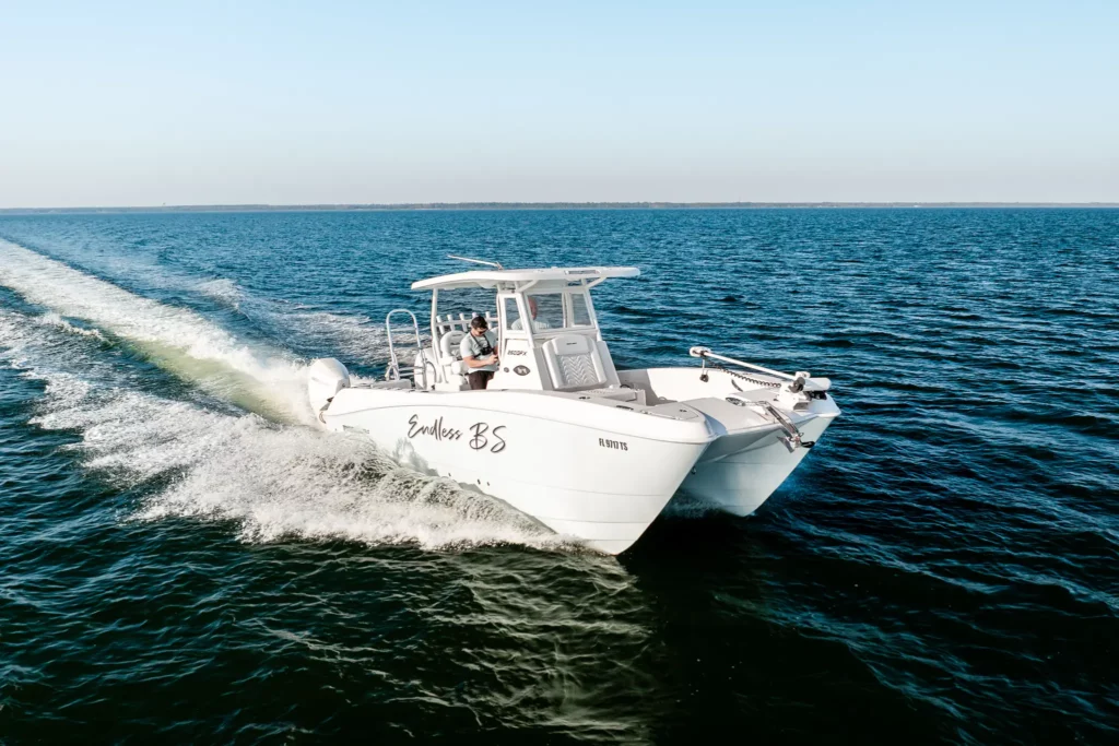 Twin Vee catamaran running flat out across open water, twin hulls clear of the chop