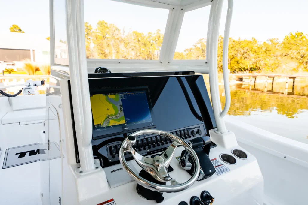 Helm of a Twin Vee catamaran under the hardtop, wheel and electronics in frame
