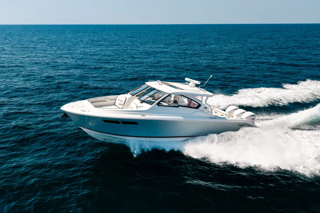 Sleek white dual-console cruiser running across open sea, leaving a broad wake