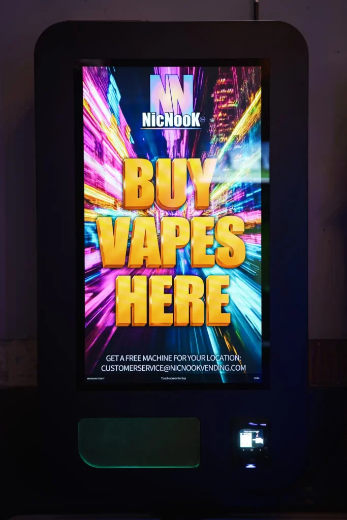 Product Photography 1 NicNook vending machine installed in a bar, the screen glowing against a dark wall under magenta house lighting